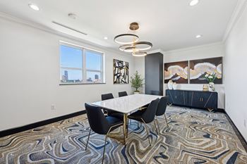Conference room with long table and seats and window looking out to city at Dominion Post Oak apartments in Houston, TX
